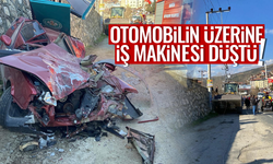 Kamyondan düşen iş makinesi park halindeki otomobili ezdi